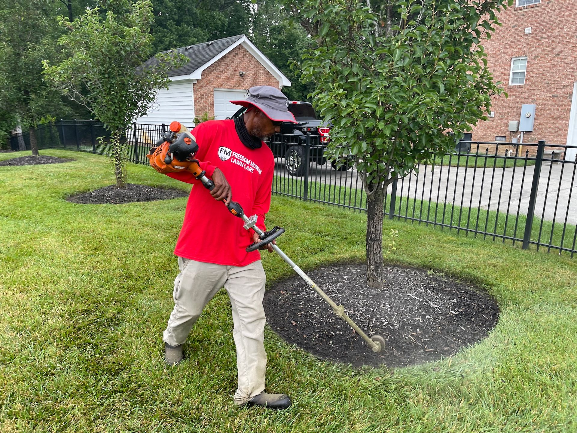 A man is using a lawn mower to cut the grass in a yard.