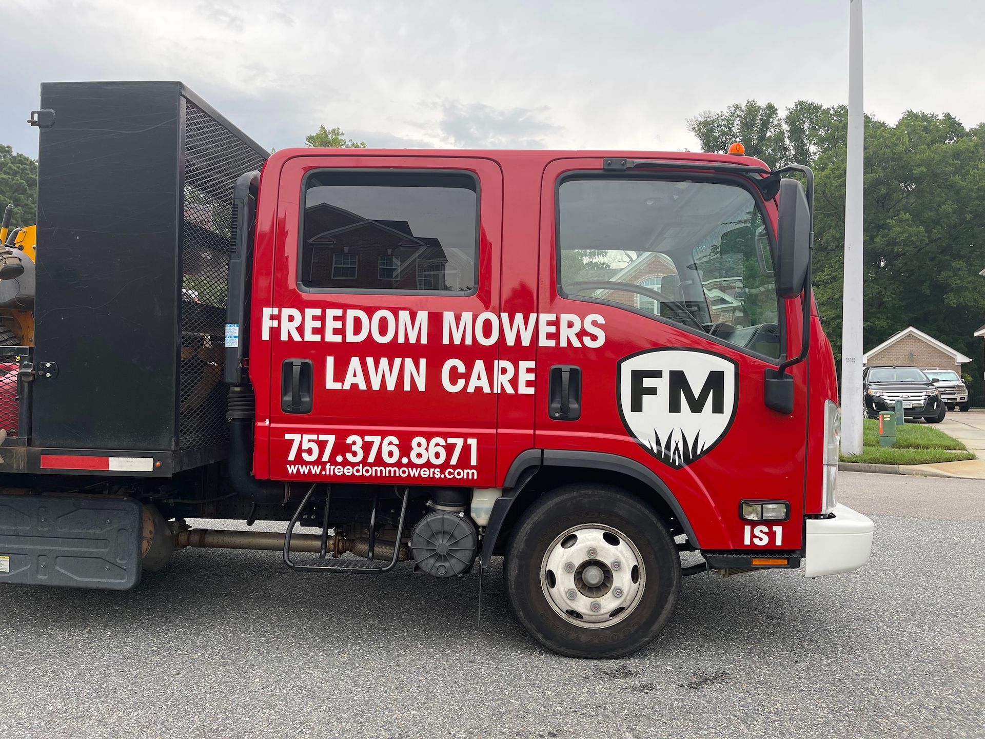 A red truck with freedom mowers lawn care written on it