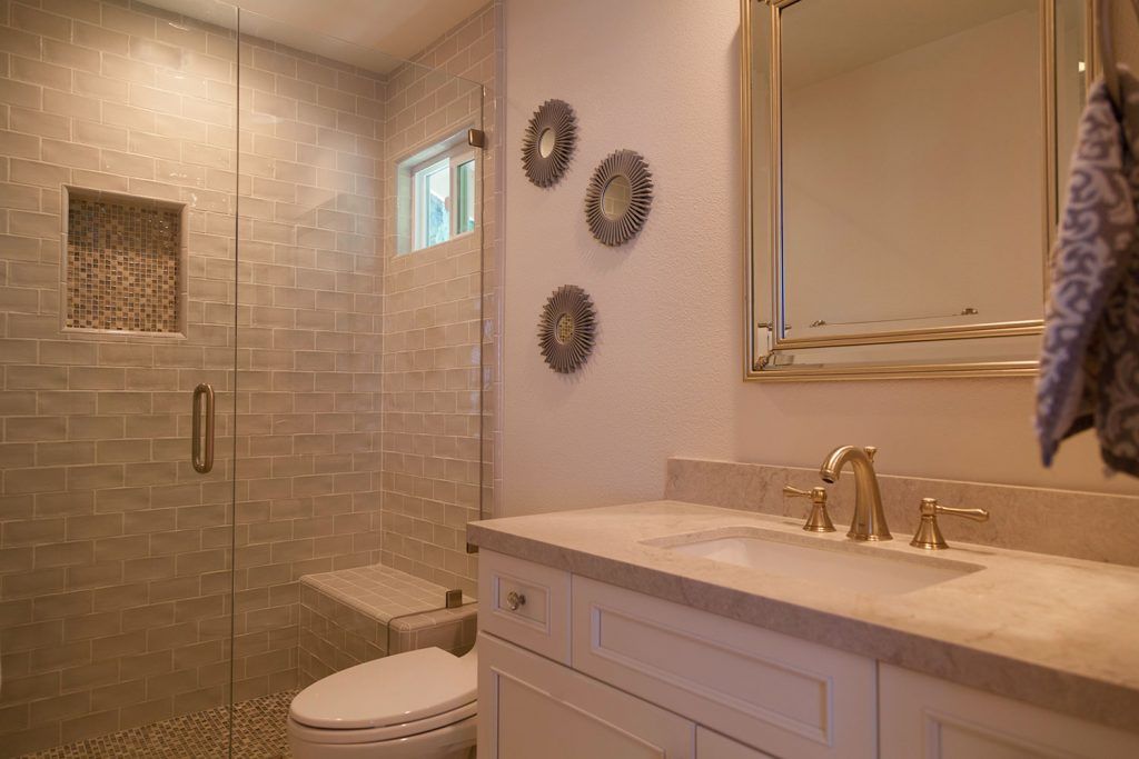 Modern bathroom with glass shower, double vanity, and wall decor