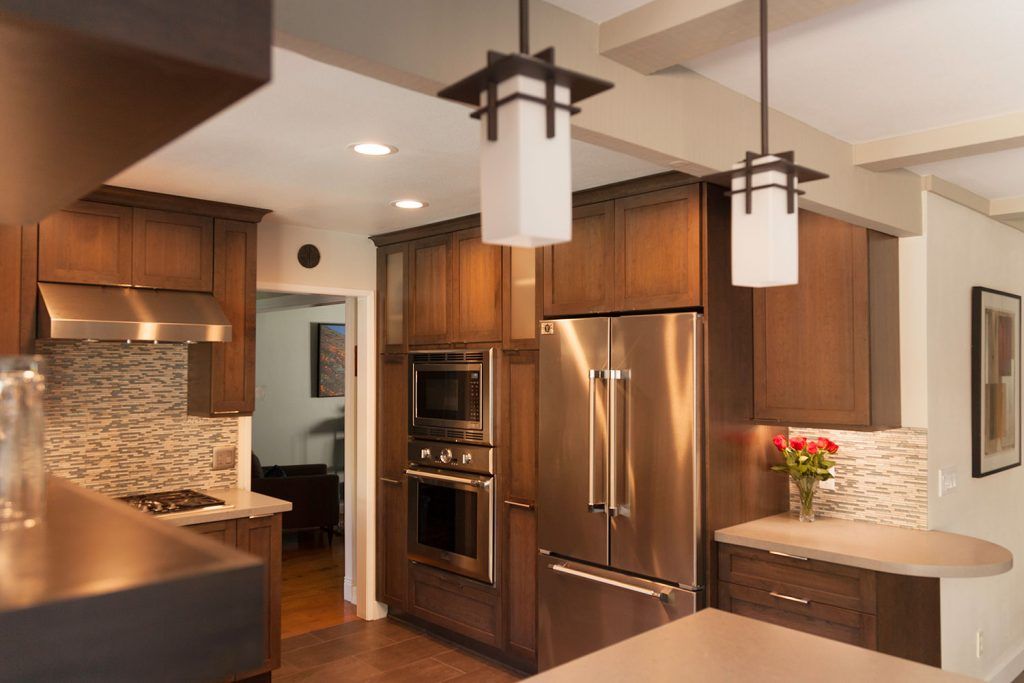 Modern kitchen with wood cabinets, stainless steel appliances, granite counters, and pendant lights