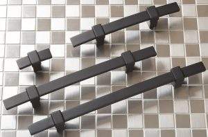 Four black hex dumbbells on a gray checkered surface, arranged diagonally.