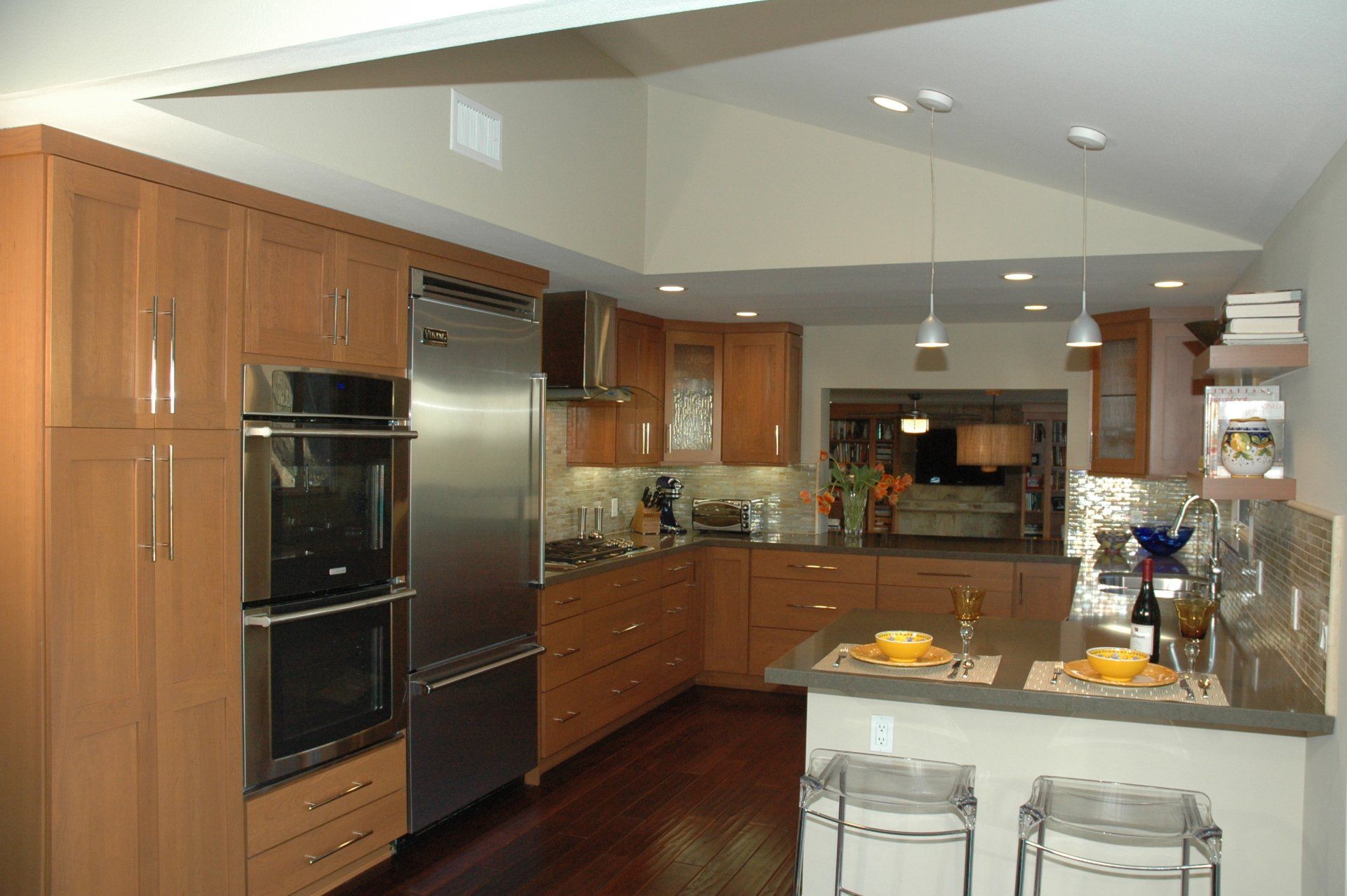 Modern kitchen with wood cabinets, stainless steel appliances, island, and dark hardwood floor