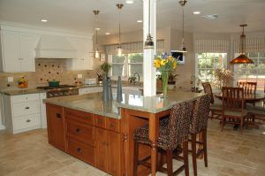 Modern kitchen with island, pendant lights, and dining area in warm wood and neutral tones