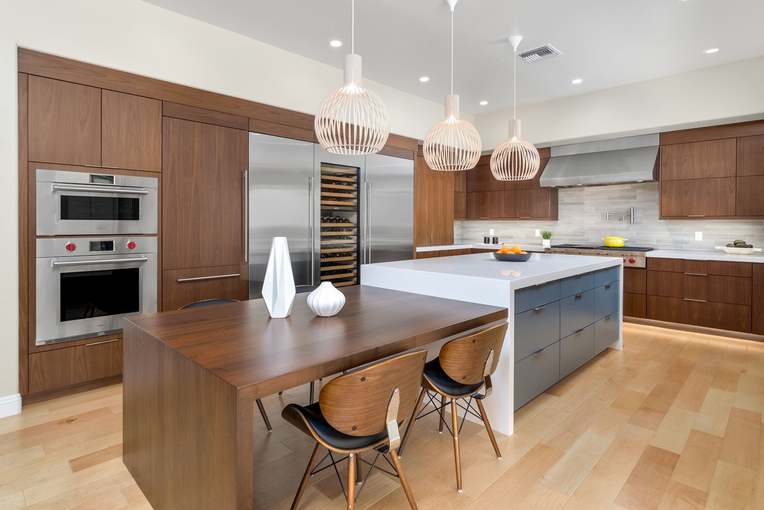Modern kitchen with dark wood cabinets, large island, and two hanging pendant lights