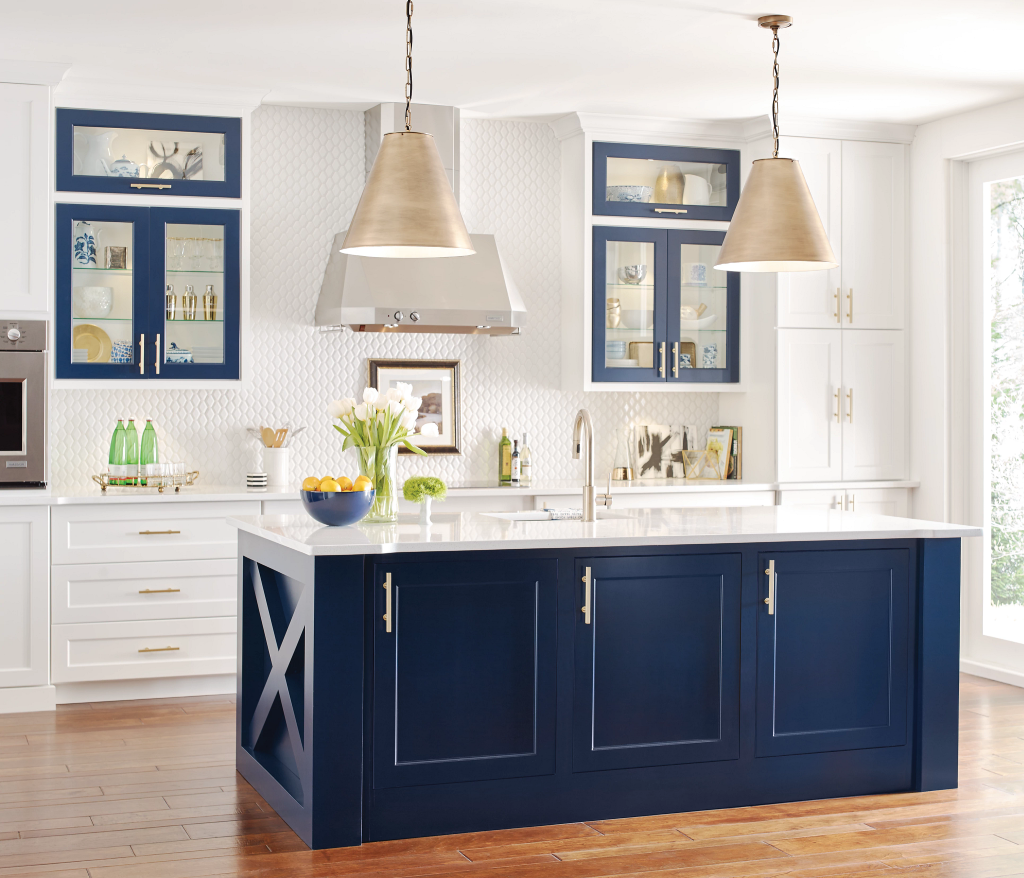 Bright kitchen with navy island, white cabinets, pendant lights, and hardwood floors