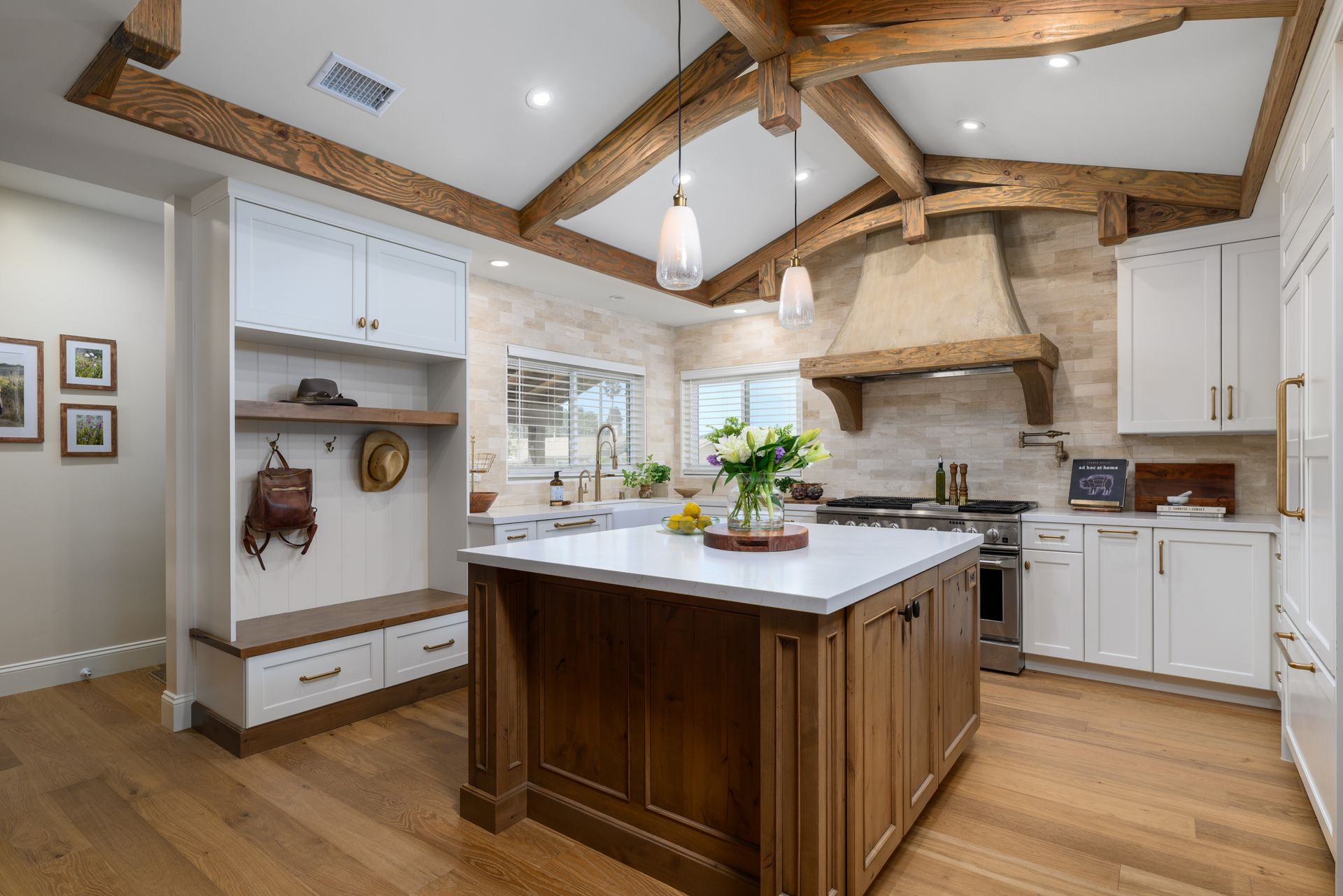 Bright modern kitchen with wood beams, white cabinets, and a large island center.