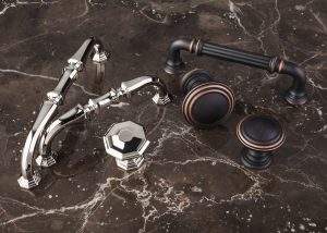 Chrome and black faucet and knobs on a dark marble surface