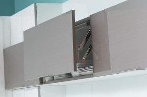 Open cabinet doors with stacked dishes and cookware inside