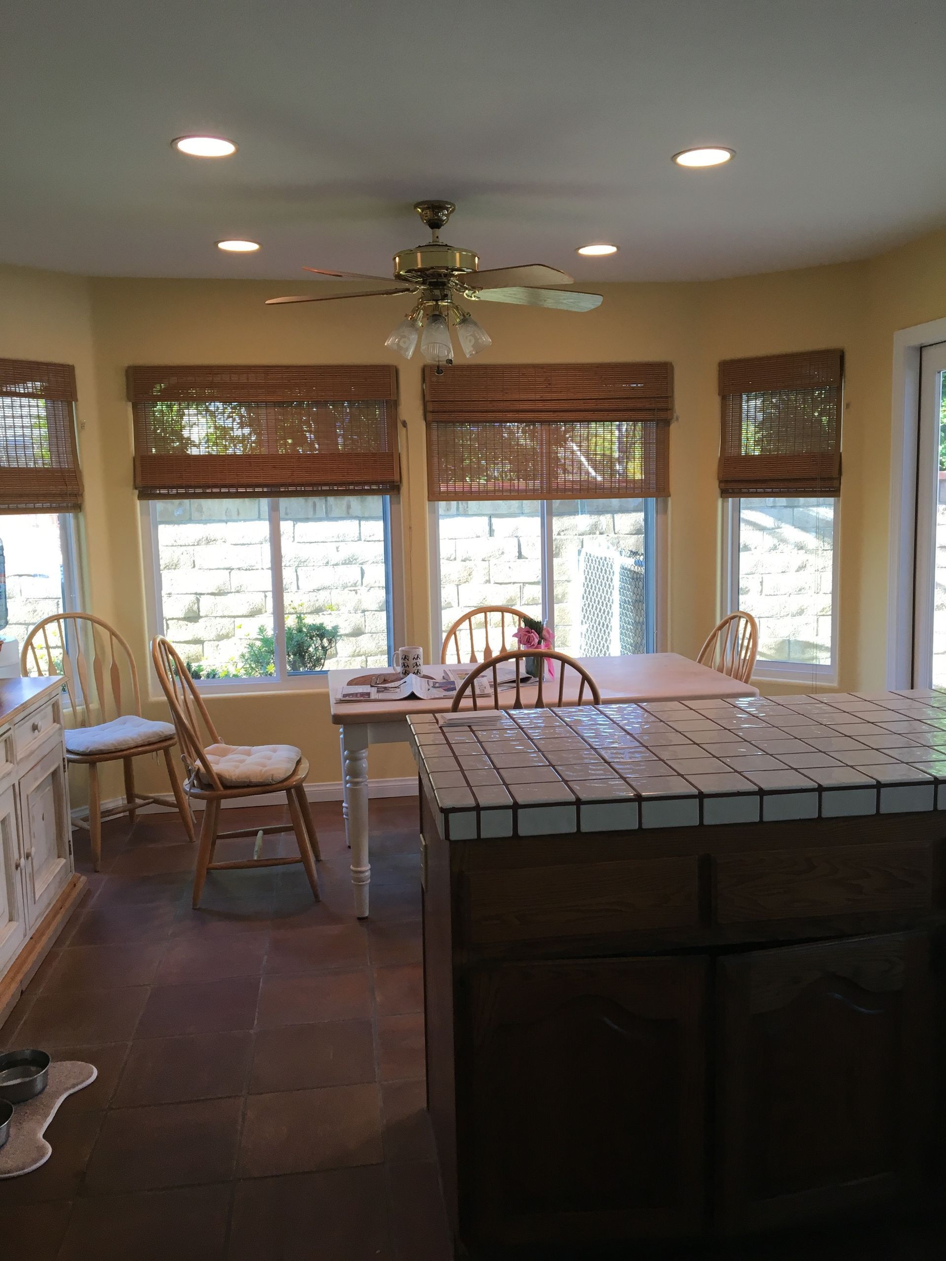 Bright sunroom with dining table, wooden chairs, and large windows letting in natural light