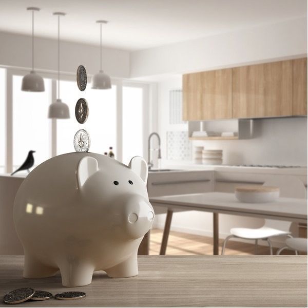 White piggy bank on a wooden table in a bright modern kitchen