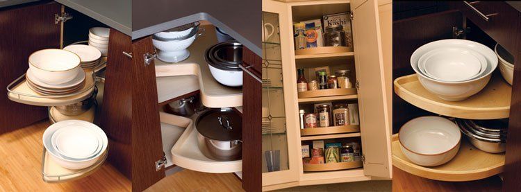 Built-in kitchen cabinet with pull-out shelves holding stacked white dishes and cookware