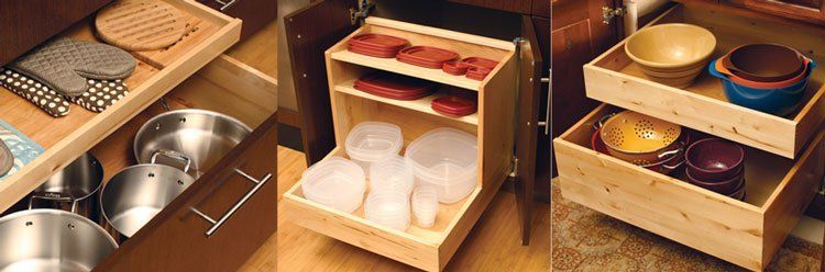 Wooden kitchen organizers with bowls, plates, and utensils in a tidy cabinet drawer display
