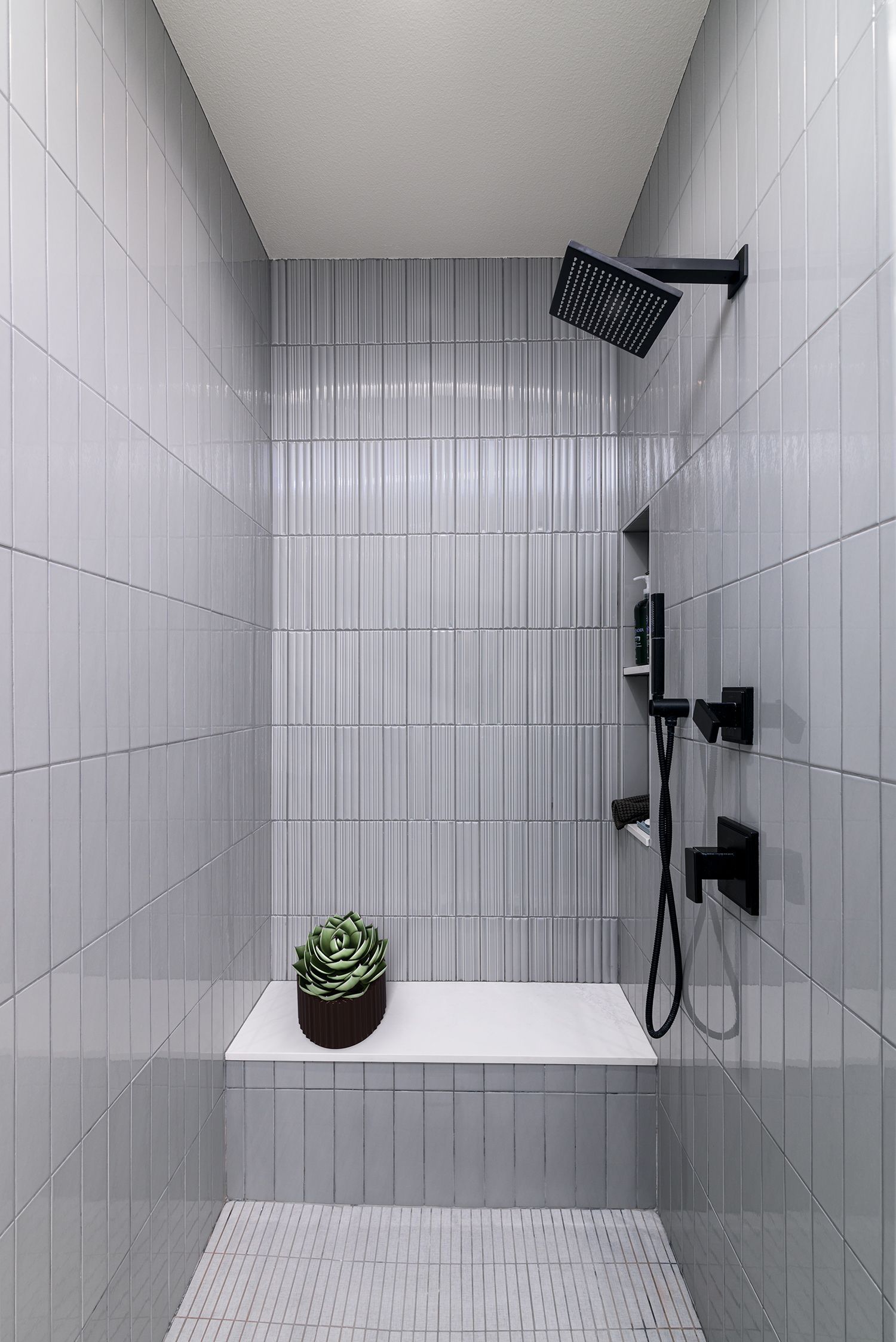 image shows the inside of a shower with smooth and ribbed subway tiles in soft gray, Primary Bathroom Remodel, Thousand Oaks, CA 