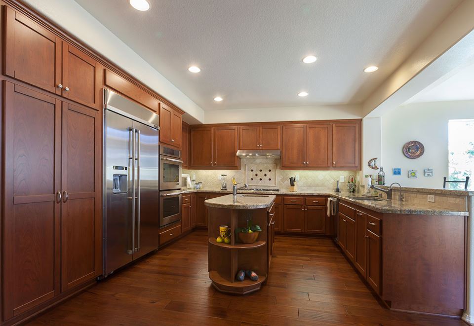Modern kitchen with wood cabinets, stainless steel appliances, granite counters, and a center island