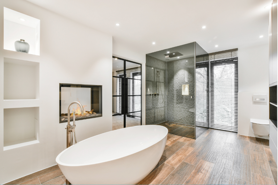 Modern bathroom with freestanding tub, glass shower, and white built-in shelving