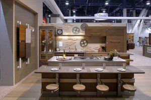 Modern kitchen showroom with island, stools, wood cabinets, and display counters