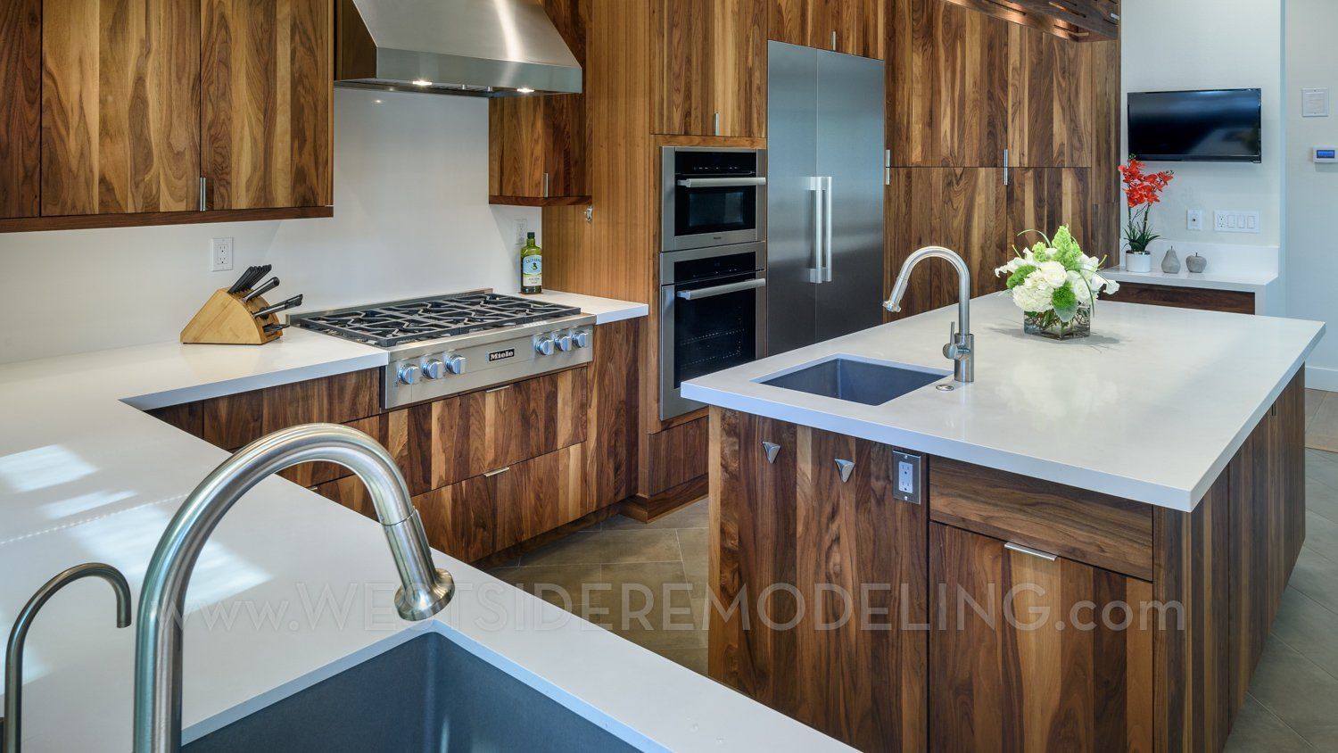 Modern kitchen with wood cabinets, stainless steel appliances, and a large white island with sink