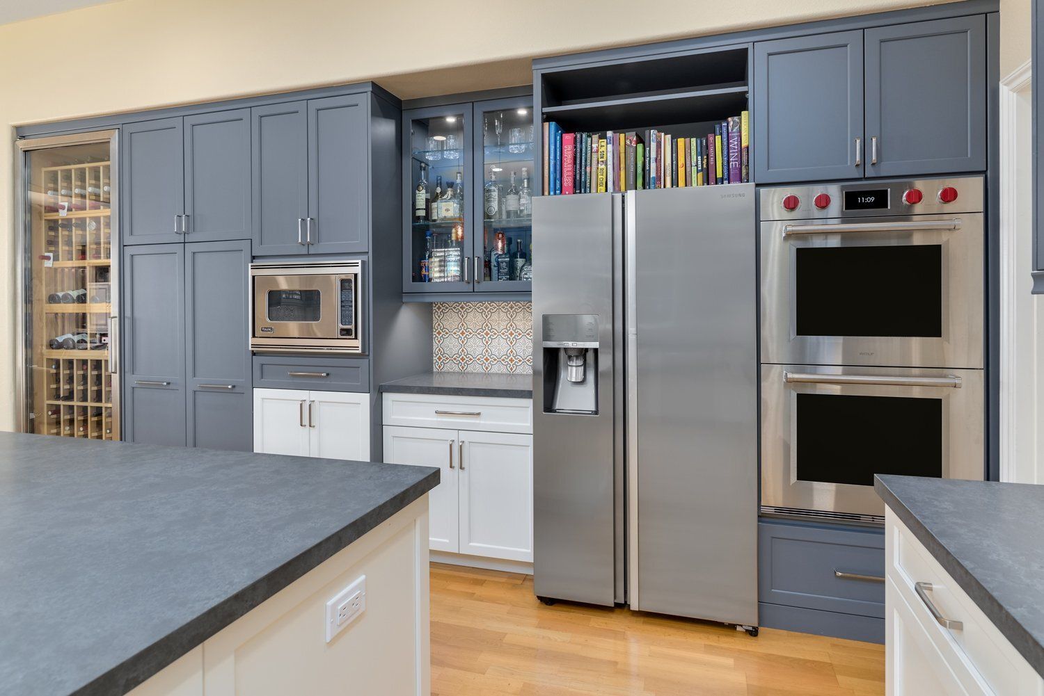 Modern kitchen with gray cabinets, stainless steel appliances, and a large island