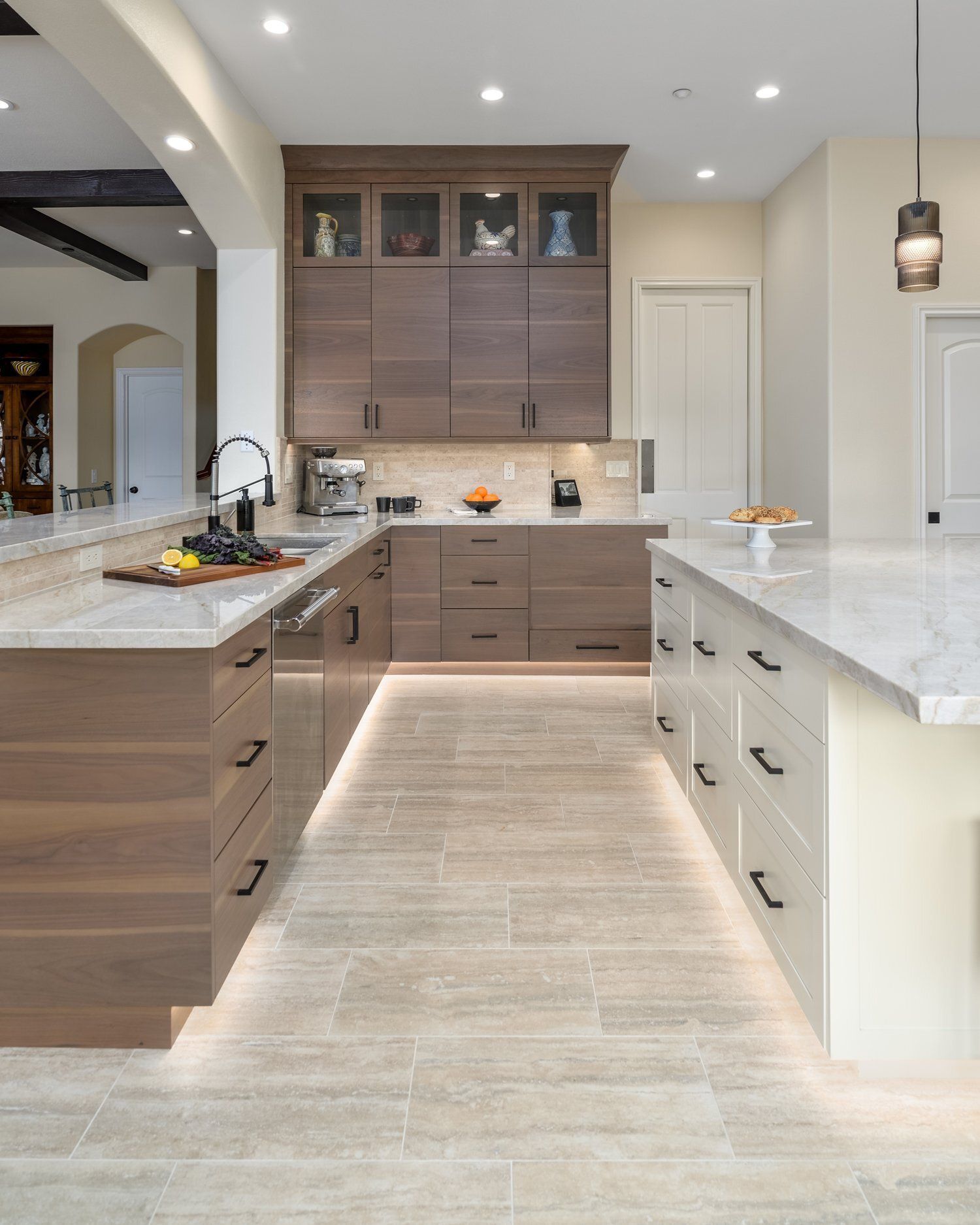 Modern kitchen with wood cabinets, marble island, and light tile flooring