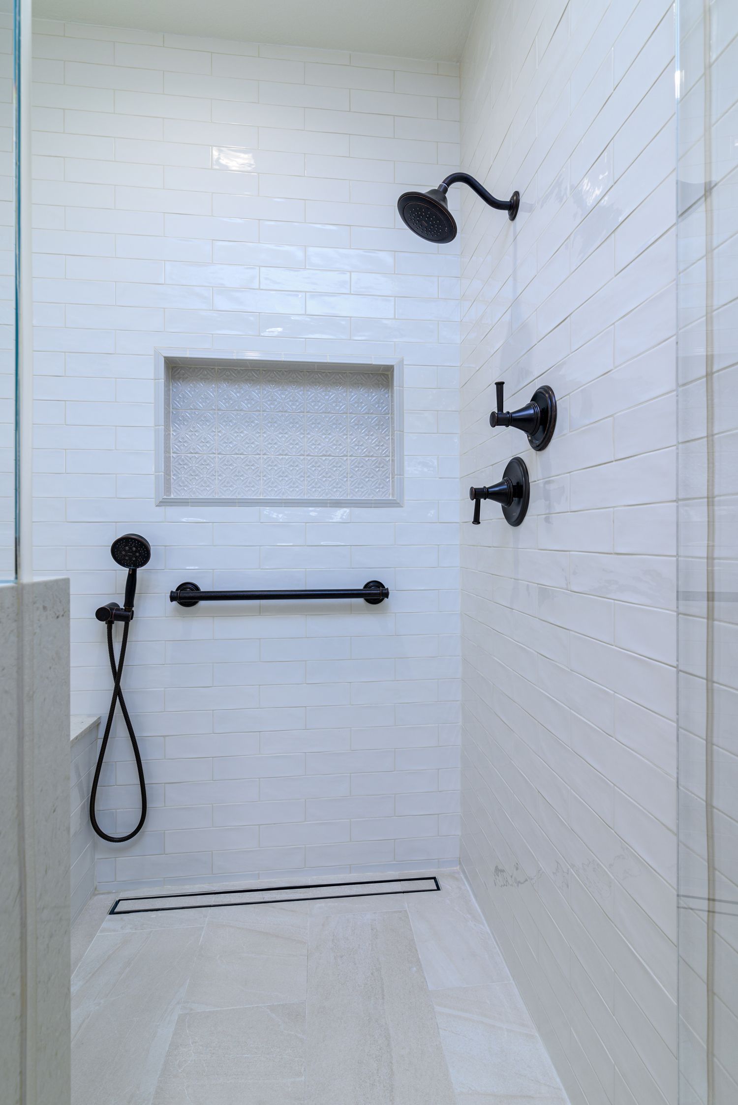 Image of a shower with light cream colored subway field tile, beige non-slip shower floor tile, shampoo niche, curbless shower, barrier free shower entrance, grab bar, Master Bathroom Addition, Thousand Oaks, CA 