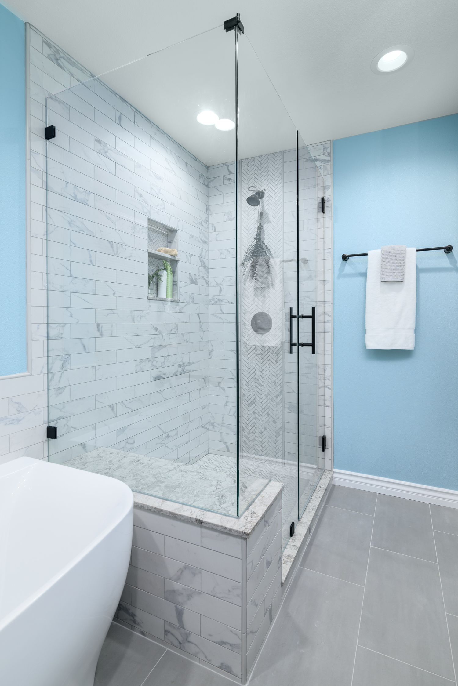primary master bathroom shower remodel with subway and herring bone porcelain tile, shower bench, shampoo niche, glass shower door enclosure Oak Park , CA 