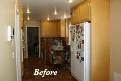 Narrow kitchen with wood cabinets and white fridge, labeled “Before”