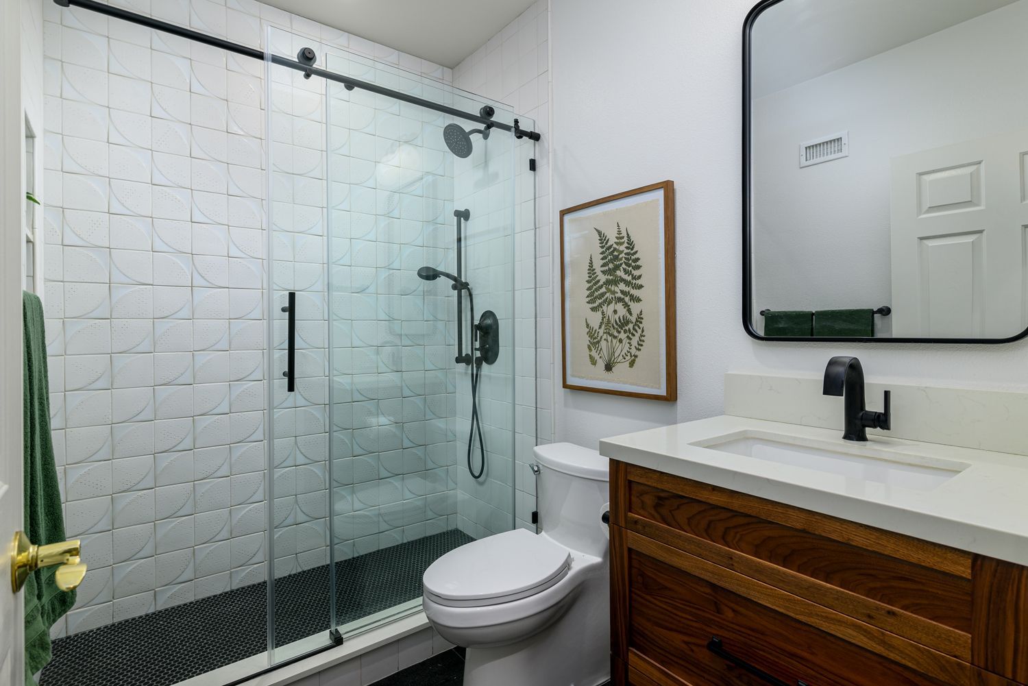 Modern bathroom with glass shower, toilet, and wooden vanity with mirror