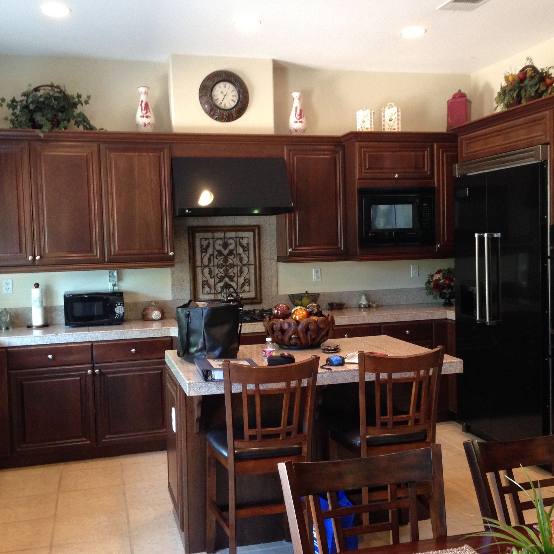 Dark cherry wood kitchen with black appliances before remodel, Hidden Hills