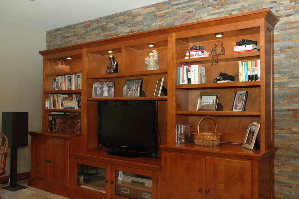 Wooden wall unit with TV, shelves, and decorative items in a living room