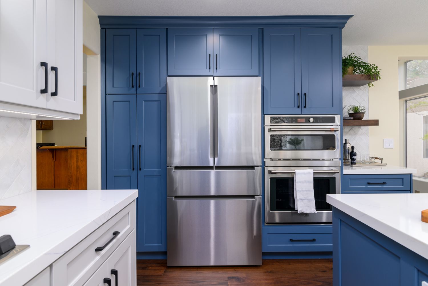 Image of a refrigerator, microwave and oven in a kitchen, rich blue and light gray cabinetry, white quartz countertops, floating shelves, Camarillo, Ca Kitchen Remodel