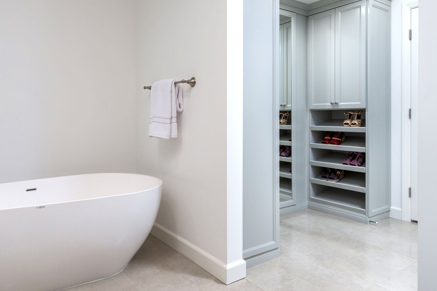 Modern bathroom with a freestanding tub and a walk-in closet doorway beside it