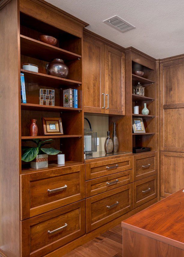 Wooden built-in office cabinets with shelves, drawers, and decorative items