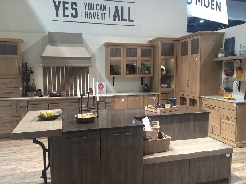 Modern kitchen showroom with islands, wood cabinets, and stainless steel appliances