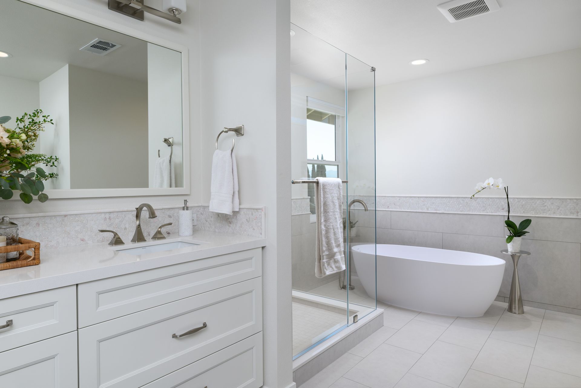Open primary bathroom with freestanding solid-surface tub, glass shower enclosure, and marble tile wainscot, Chanteclair Thousand Oaks remodel by Westside Remodeling