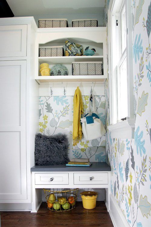 Built-in nook with bench, drawers, shelves, and floral wallpaper in a bright room