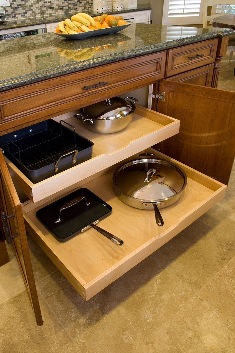 Open buffet counter with soup tureens, trays, and serving dishes on wooden pull-out shelves.