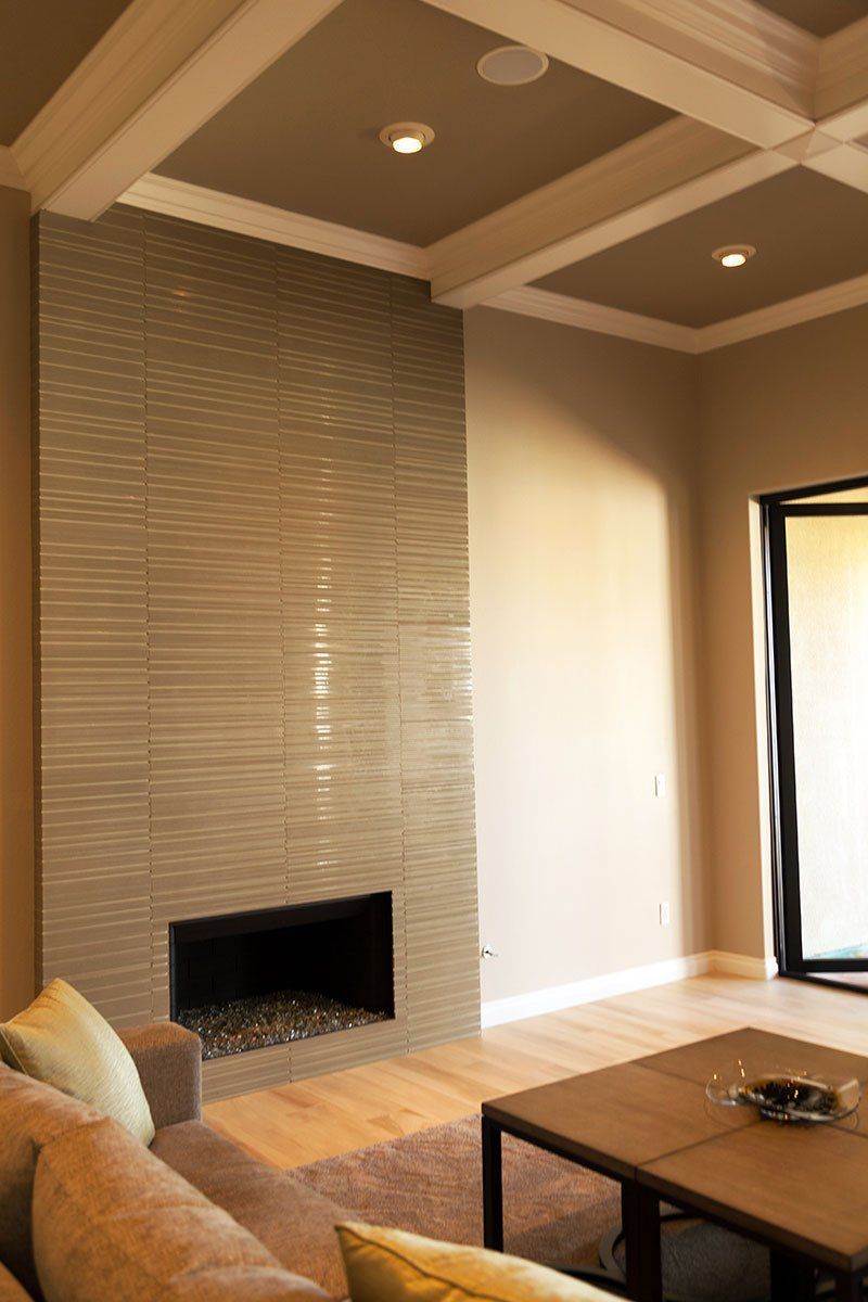 Modern living room with tiled fireplace, recessed ceiling lights, and coffee table