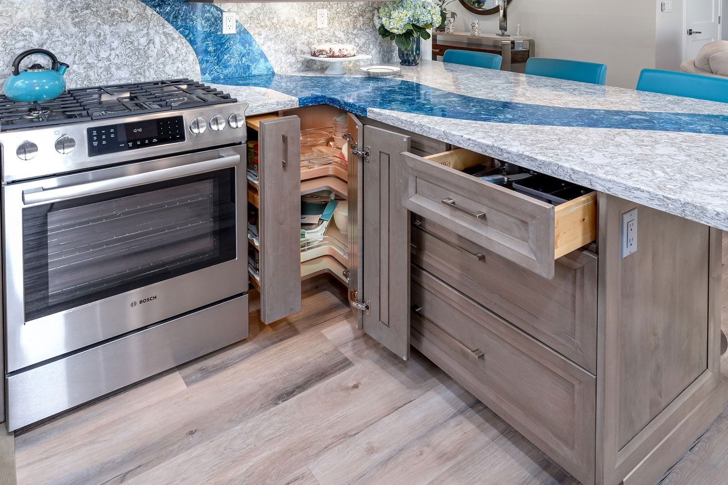Modern kitchen with stainless steel oven, open trash cabinet, and blue speckled countertop