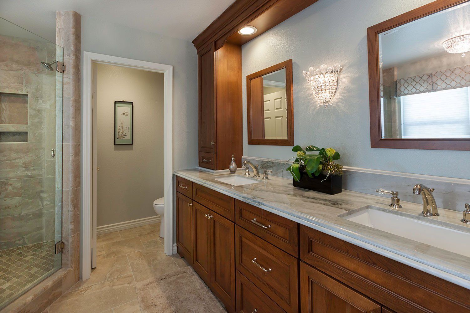 Luxury bathroom with double vanity, large mirror, and glass shower in neutral tones