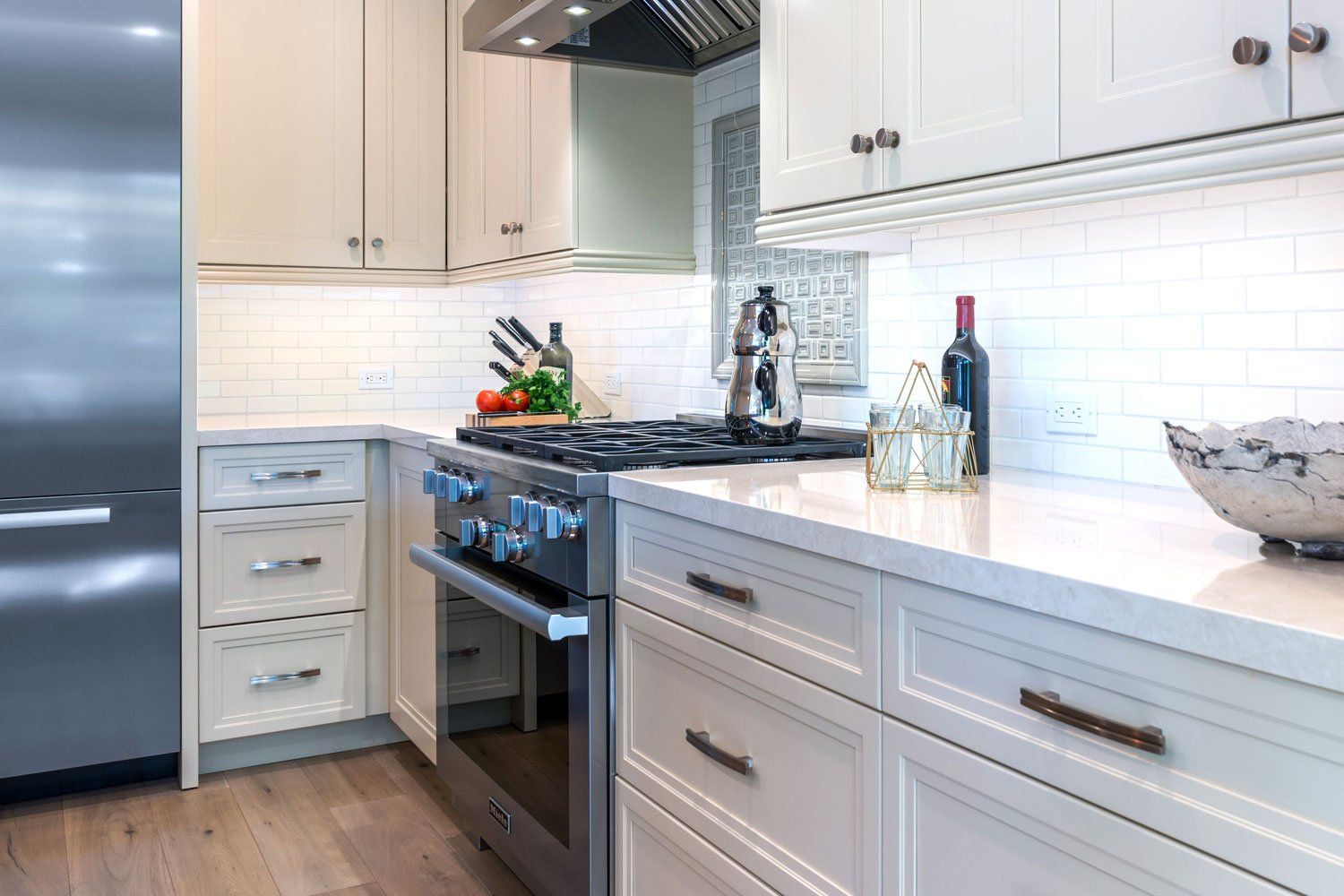 Bright white kitchen with stainless steel appliances, farmhouse sink, and gray countertops