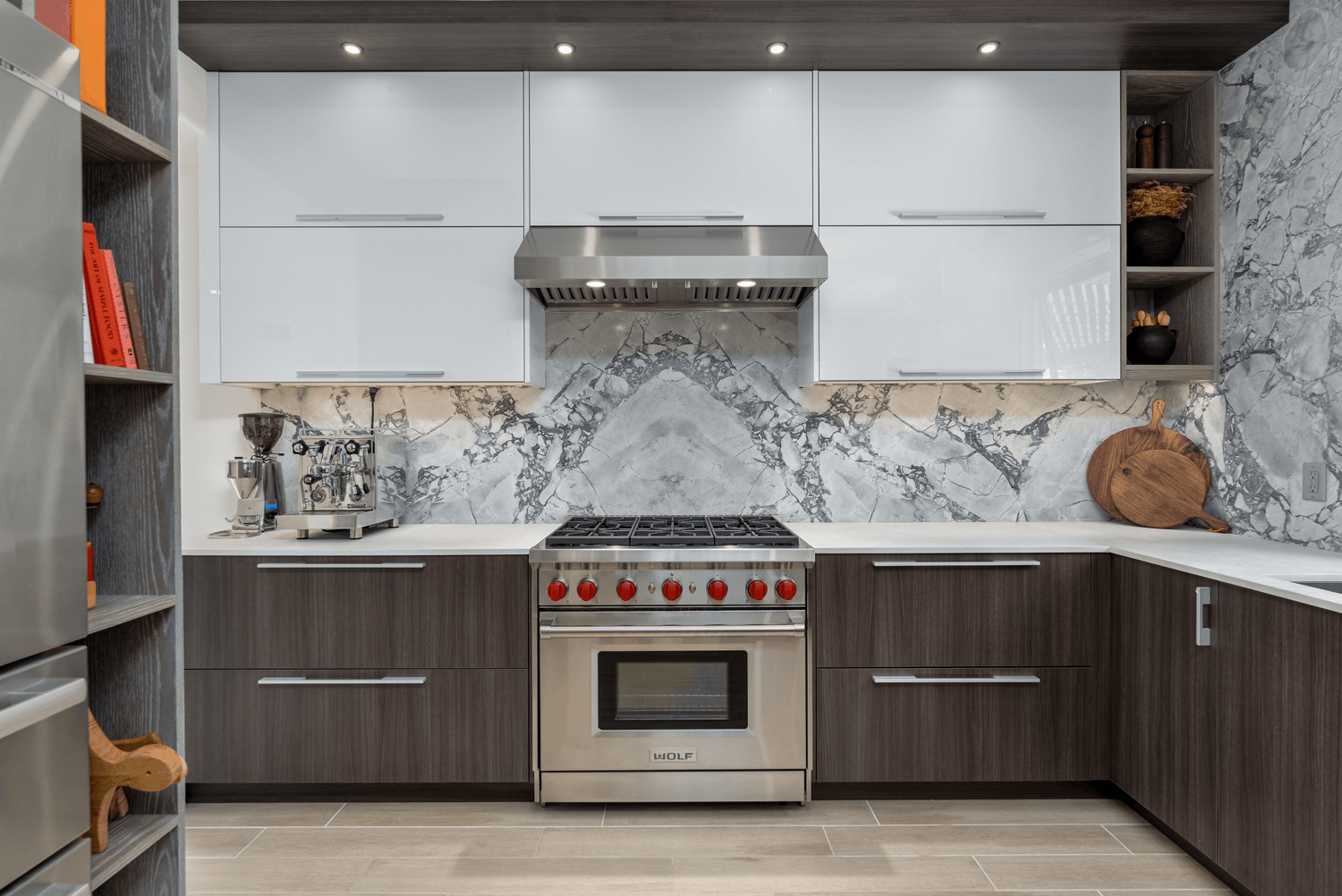 Modern kitchen with gray cabinets, stainless-steel stove, and marble-pattern backsplash