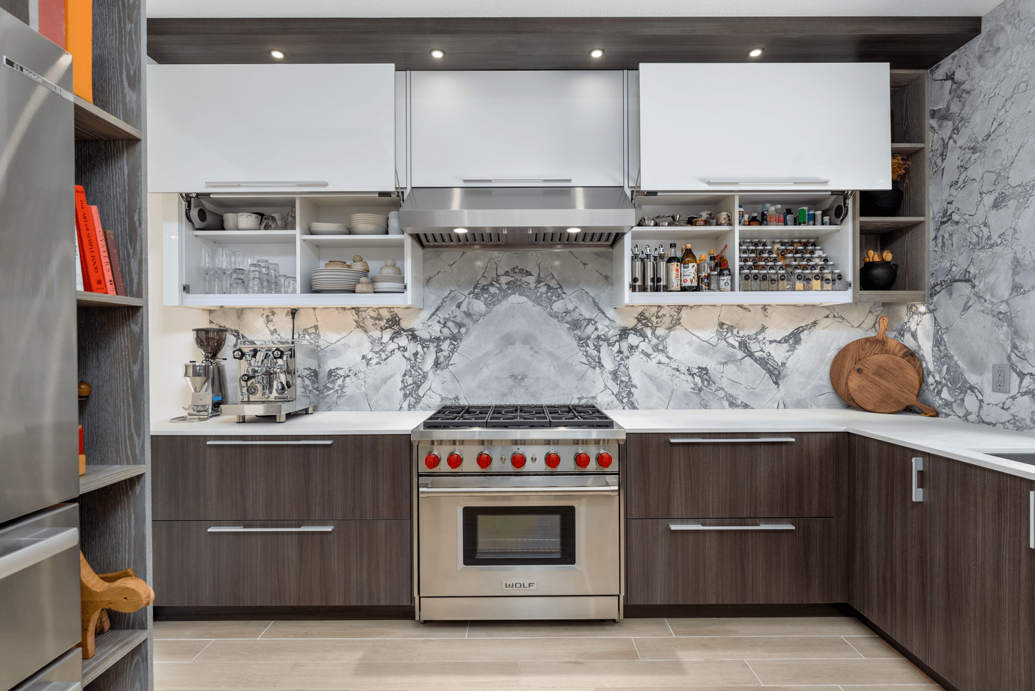 Modern kitchen with white and wood cabinets, marble backsplash, and stainless steel oven