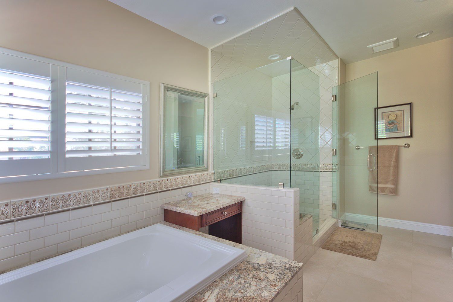 Modern bathroom with a soaking tub, glass shower, beige tile, and window shutters