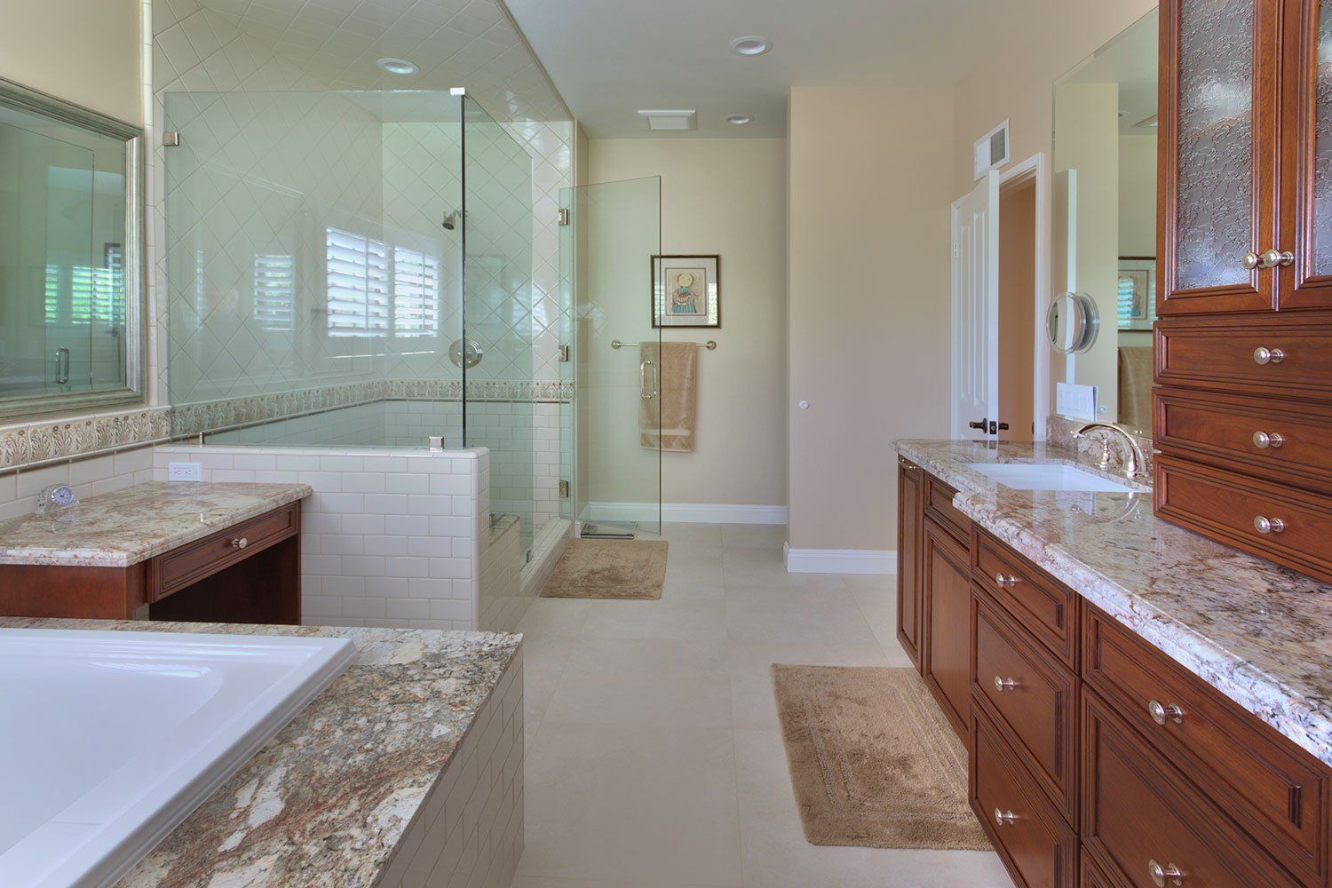 Spacious beige bathroom with glass shower, soaking tub, and wood double vanity with granite countertop