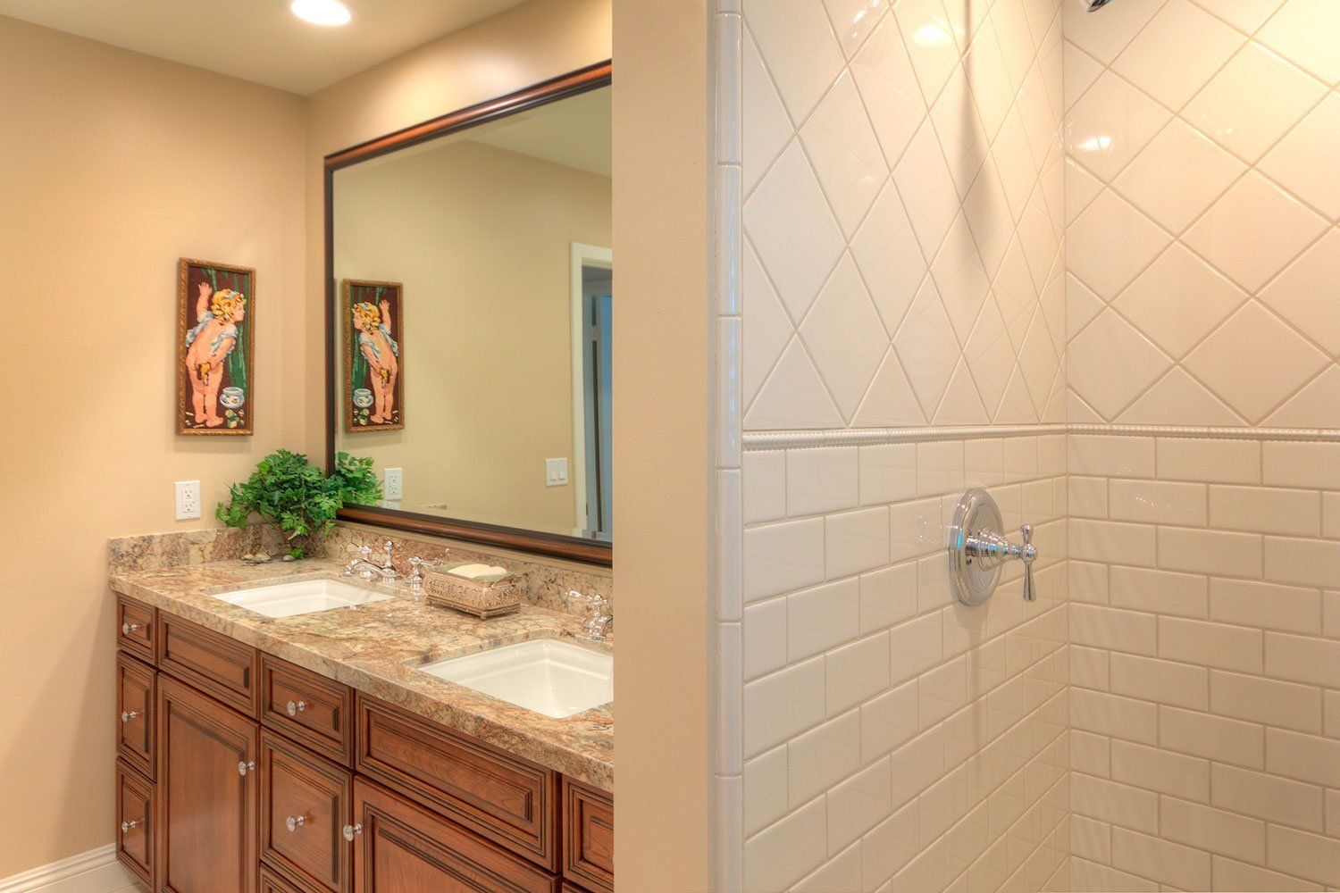 Bathroom vanity with double sinks, large mirror, and tiled shower stall.