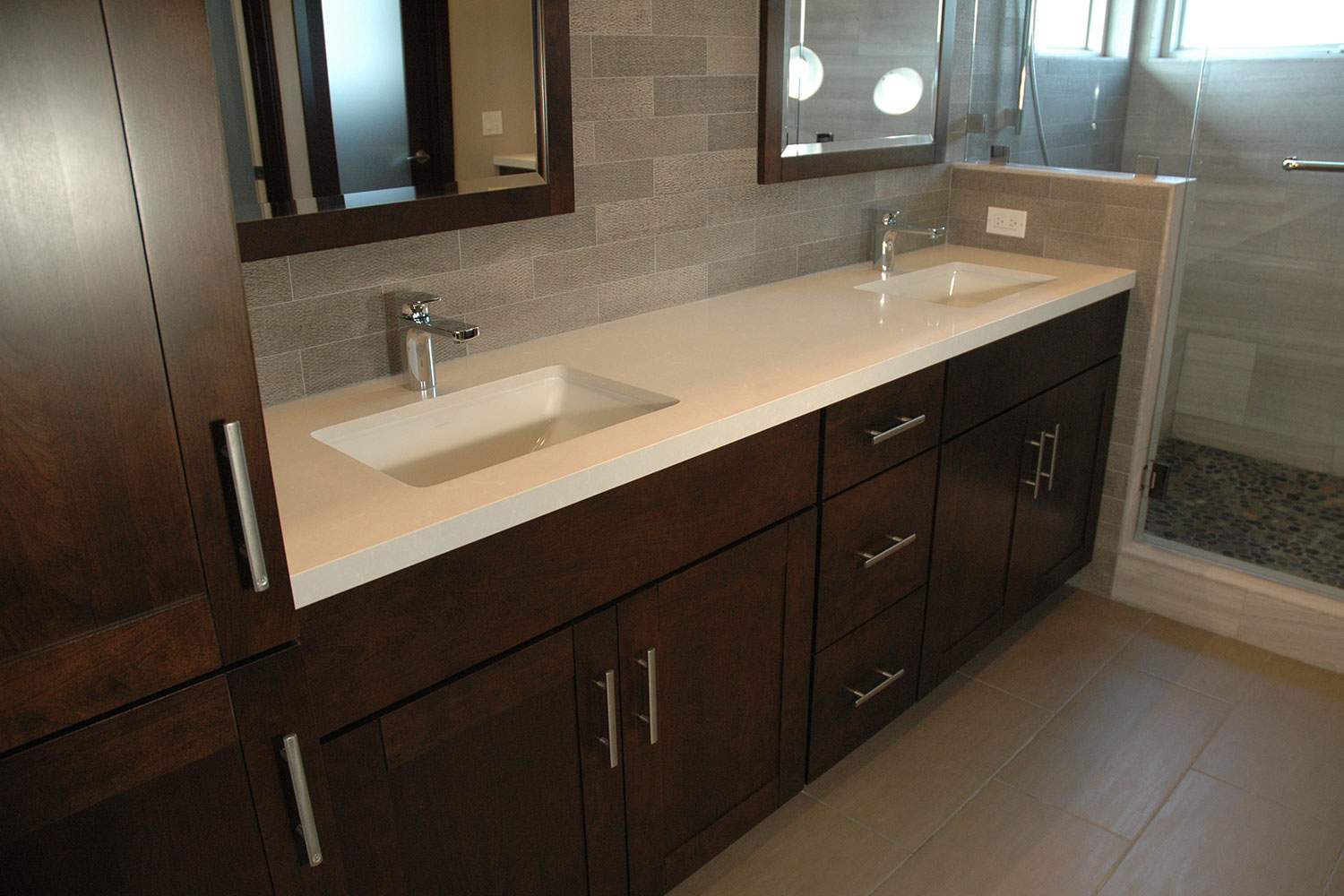 Modern bathroom vanity with double sinks, dark wood cabinets, and a large mirror
