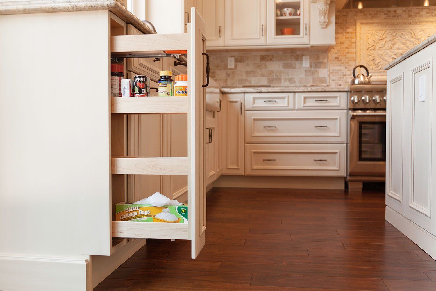 Kitchen drawer organizer with food items and utensils, open in a white and wood kitchen