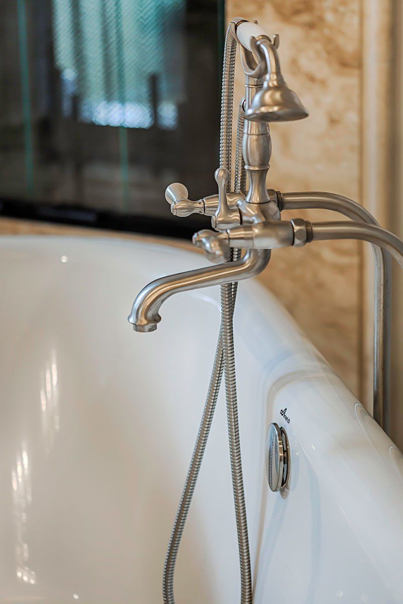 Vintage chrome faucet over a white clawfoot bathtub in a bathroom