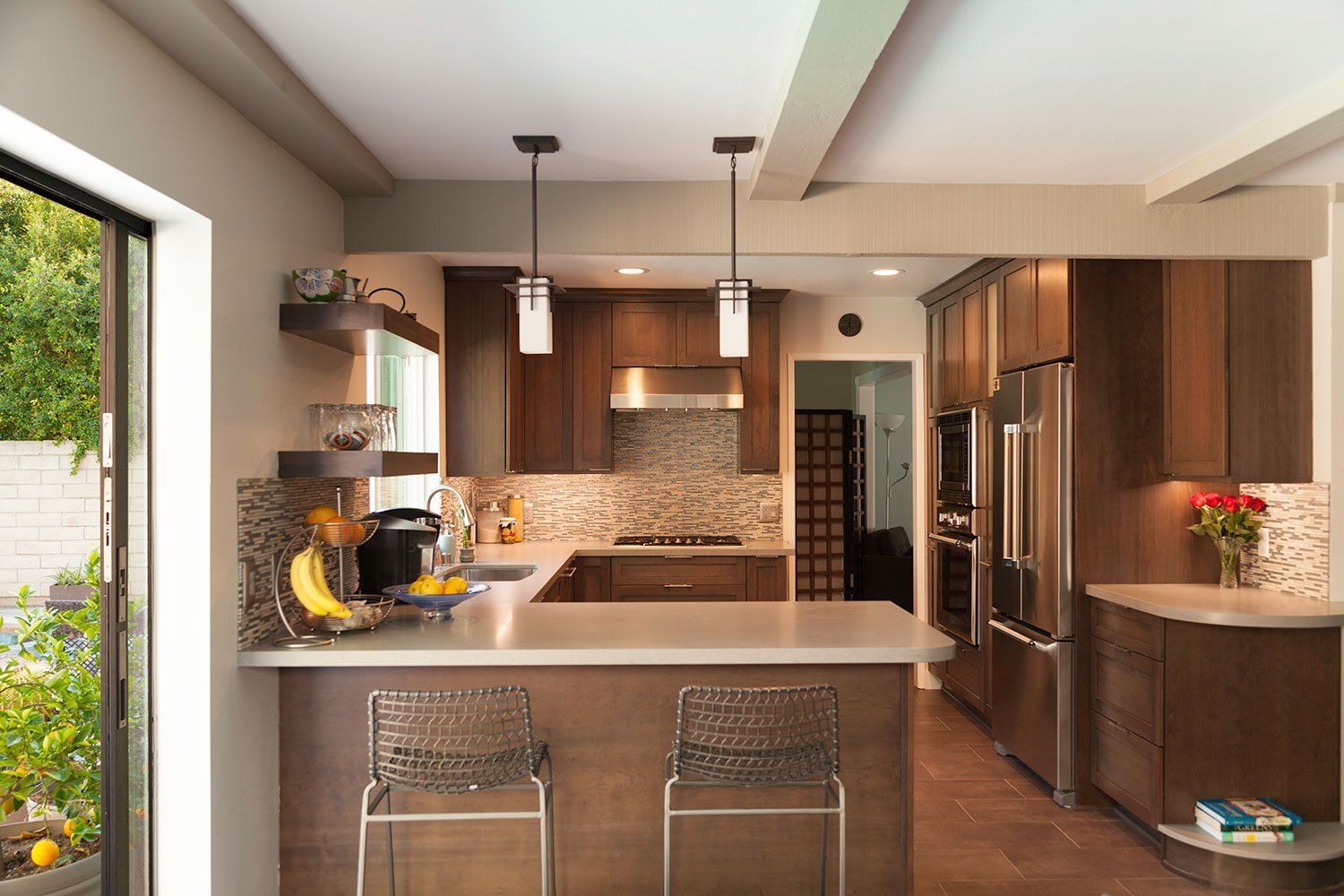Modern kitchen with wood cabinets, island seating, and stainless steel appliances