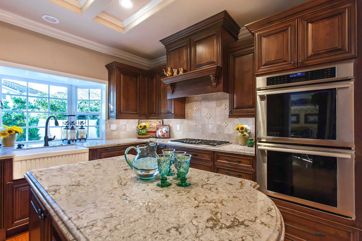 Modern kitchen with dark wood cabinets, granite island, and built-in double ovens